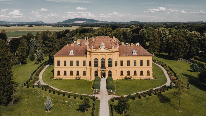 Luftaufnahme von Schloss Eckartsau umgeben von gr&uuml;ner Landschaft.