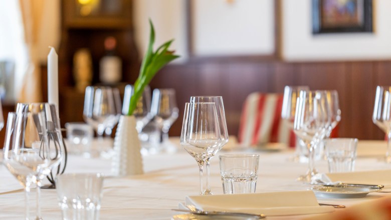 Eleganter Tisch im Hotel Post mit Weingl&auml;sern, Kerze und Blumenvase.