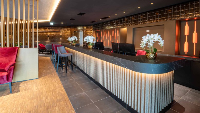 Moderne Hotelrezeption mit stilvoller Beleuchtung und Dekoration.