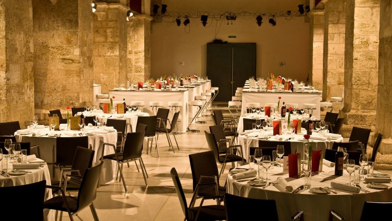 Eleganter Bankettsaal in einer historischen Kirche mit gedeckten Tischen und Stühlen.