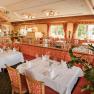 Elegantes Restaurant mit gedeckten Tischen und roten Polsterm&ouml;beln.