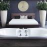 Moderner Spa-Bereich mit Badewanne, Bett und Pflanzen.