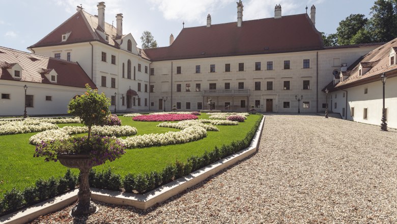 Schloss Thalheim mit gepflegtem Garten und Kiesweg.