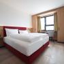 Doppelbett in hellem Zimmer mit Fenster