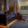 Luxuri&ouml;ses Hotelzimmer mit Himmelbett und freistehender Badewanne.