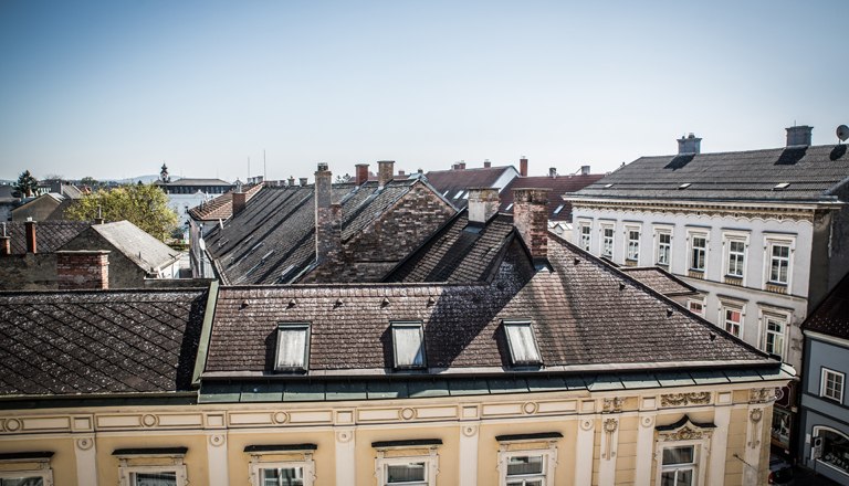 Ausblick auf D&auml;cher der Nachbargeb&auml;ude und blauem Himmel.