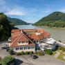 Hotel ResidenzWachau am Flussufer mit umliegenden H&uuml;geln.