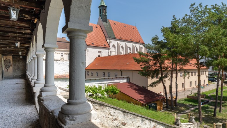 Blick auf die Kapuzinerkirche in Wiener Neustadt mit Arkaden im Vordergrund.
