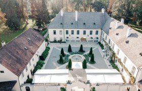 Luftaufnahme eines historischen Schlosses mit Innenhof und Garten.