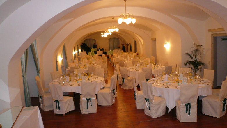 Eleganter Festsaal mit gedeckten Tischen und St&uuml;hlen im Schloss Gloggnitz.