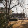Hotel Schneeberghof im Sonnenlicht mit B&auml;umen im Vordergrund.