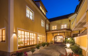Innenhof des Hotel Zum Schwarzen Bären mit beleuchteten Fenstern und Pflanzen bei Nacht.