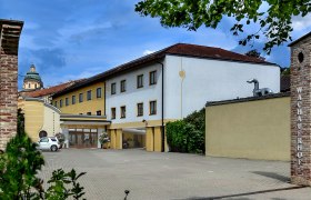 Au&szlig;enansicht des Wachauerhofs in Melk mit Parkplatz und Geb&auml;udefassade.
