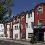 Au&szlig;enansicht des Restaurant-Hotels Wallner mit roter und wei&szlig;er Fassade.