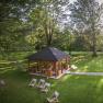 Ein Pavillon im Park mit Liegest&uuml;hlen und B&auml;umen.