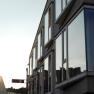 Moderne Geb&auml;udefassade mit gro&szlig;en Fenstern im Sonnenuntergang.