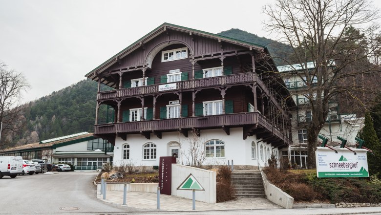 Hotel Schneeberghof in einer bergigen Umgebung mit traditioneller Architektur und einem gro&szlig;en Schild vor dem Geb&auml;ude.