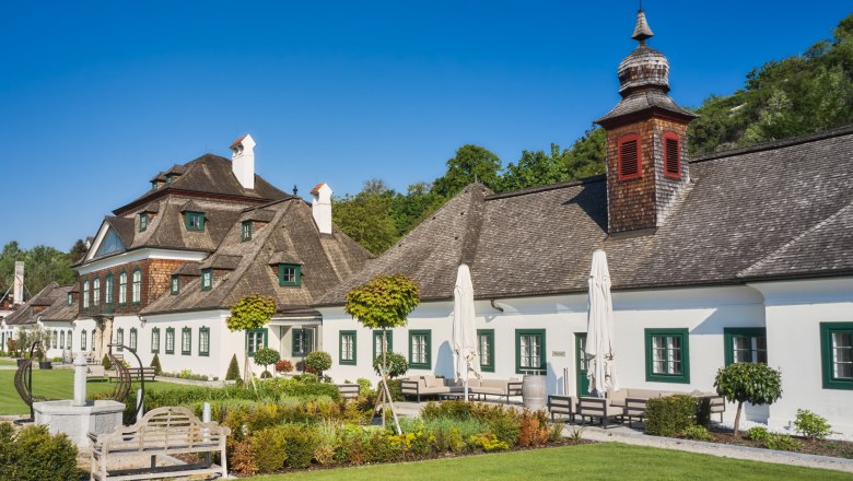 Schloss Luberegg mit gepflegtem Garten und blauen Himmel.