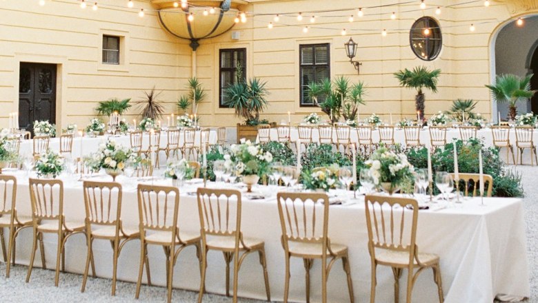 Innenhof von Schloss Eckartsau mit festlich gedeckten Tischen und Lichterketten.