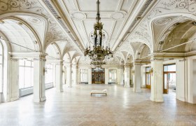 Großer, eleganter Speisesaal mit verzierten Decken und Kronleuchtern im Südbahnhotel.