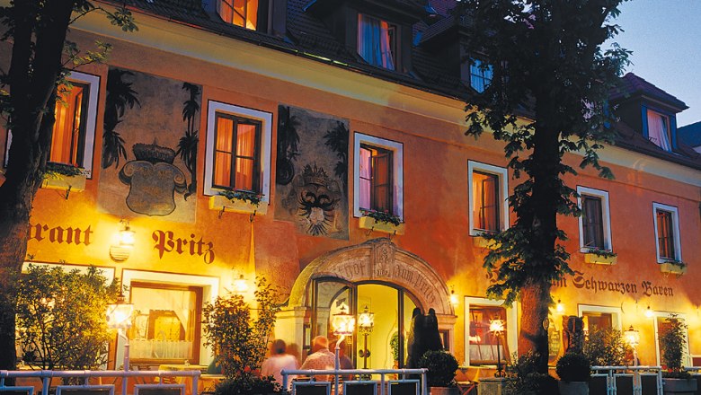 Historisches Geb&auml;ude des Hotels Zum Schwarzen B&auml;ren bei Nacht, beleuchtet mit warmem Licht.