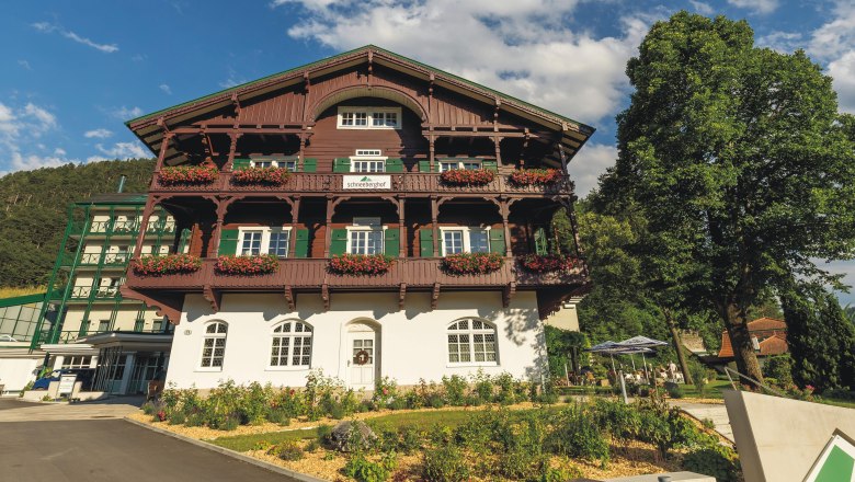 Hotel Schneeberghof mit Blumen geschm&uuml;cktem Balkon und blauen Himmel.