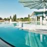 Au&szlig;enbereich der Therme Laa mit Pool und Sonnenschirmen.