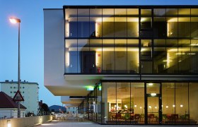 Modernes Hotelgeb&auml;ude mit Glasfassade bei D&auml;mmerung.