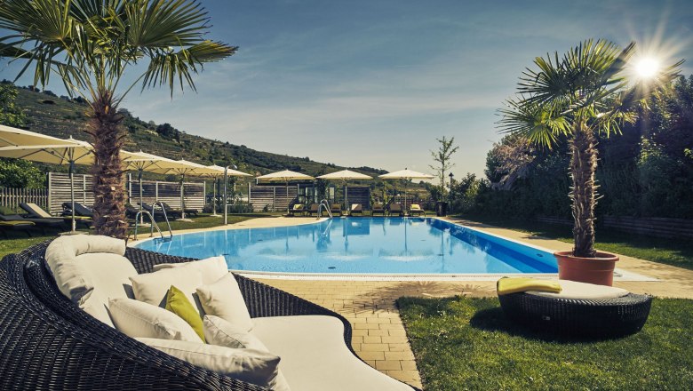 Au&szlig;enpool des Steigenberger Krems mit Liegest&uuml;hlen und Sonnenschirmen.