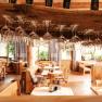 Innenansicht eines Restaurants mit h&auml;ngenden Weingl&auml;sern und Holzm&ouml;beln.