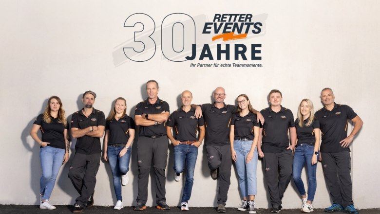 Gruppe von zehn Personen in schwarzer Kleidung vor einer Wand mit dem Logo von RETTER EVENTS und dem Text '30 Jahre'.