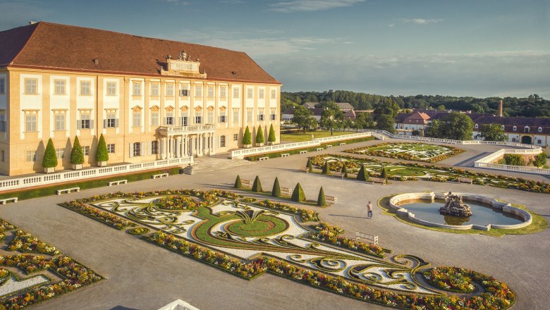 Schloss Hof mit prächtigem Barockgarten und Springbrunnen bei sonnigem Wetter.