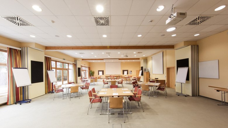 Ein leerer Konferenzraum mit Tischen, St&uuml;hlen und Flipcharts.