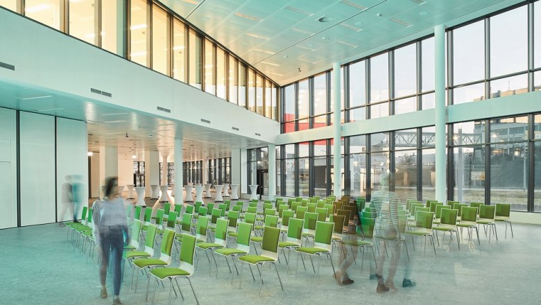 Moderner Konferenzraum mit grünen Stühlen und großen Fenstern im Vienna Airport Conference & Innovation Center.