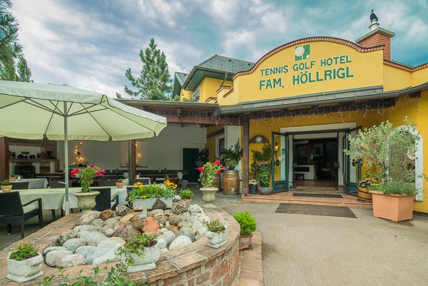 Eingang des Tennis Golf Hotels H&ouml;llrigl mit Terrasse und Pflanzen.