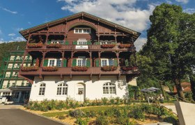 Hotel Schneeberghof mit Blumen geschm&uuml;cktem Balkon und blauen Himmel.