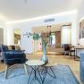 Modern eingerichtetes Hotelzimmer mit Bett, Sesseln, Tisch und Dekoration.