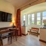 Hotelzimmer mit Schreibtisch, Stuhl, Fernseher und Fenster mit Aussicht.