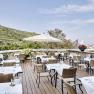 Restaurantterrasse mit gedeckten Tischen und Blick auf die Weinberge.