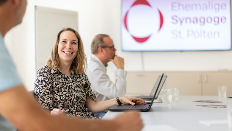 Personen in einem Seminarraum der Ehemaligen Synagoge St. P&ouml;lten, die an einem Tisch mit Laptops sitzen.