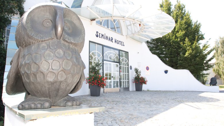 Eingang eines Seminarhotels mit Eulenskulptur.
