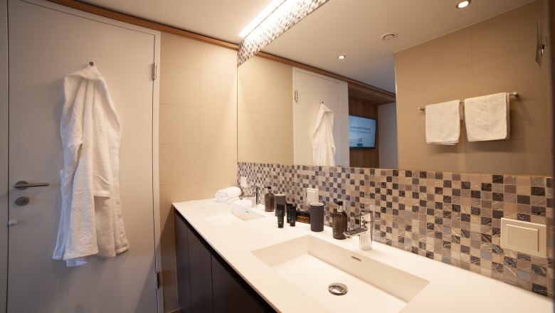 Badezimmer mit Waschbecken und Bademantel