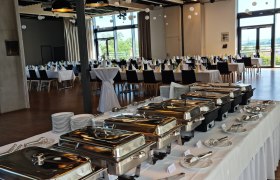 Ein festlich gedeckter Raum mit Buffet und gedeckten Tischen.