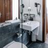 Modernes Hotelbadezimmer mit Waschbecken, Spiegel und Handt&uuml;chern.