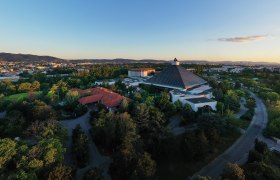 Luftaufnahme des Eventhotel Pyramide mit umliegender Landschaft bei Sonnenuntergang.