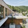Moderne Spa-Terrasse mit Holzverkleidung und Blick auf bewaldete H&uuml;gel.