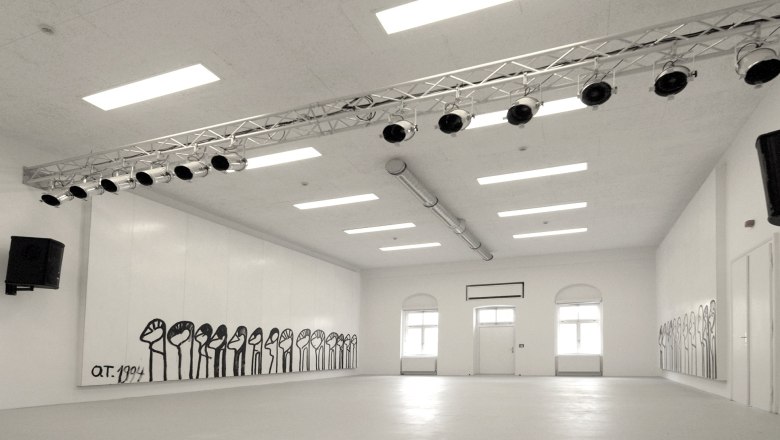 Innenansicht eines wei&szlig;en Raumes mit Wandmalereien und Beleuchtung.