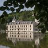 Schloss Hernstein spiegelt sich in einem See, umgeben von Bäumen.