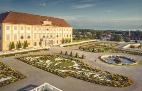 Schloss Hof mit prächtigem Barockgarten und Springbrunnen bei sonnigem Wetter.