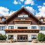 Ein traditionelles Hotel mit Holzbalkonen und Blumenk&auml;sten vor einem blauen Himmel.